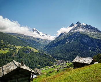 Scenic view of mountains and houses against sky