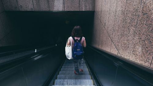 Woman standing on escalator