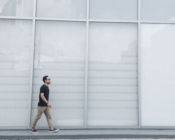 Full length of girl standing against wall