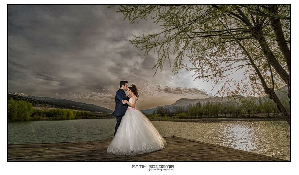 transfer print, auto post production filter, sky, lifestyles, leisure activity, water, lake, rear view, standing, mountain, tranquility, casual clothing, young adult, cloud - sky, tranquil scene, full length, nature, sitting