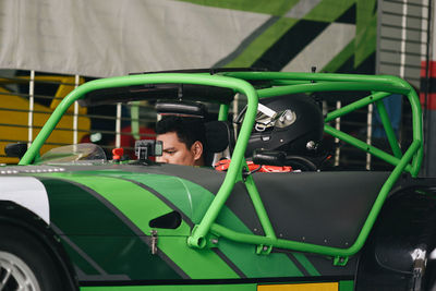 Mechanic sitting in car at garage