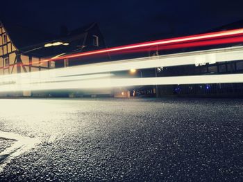 Light trails on road against sky at night