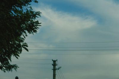 Low angle view of silhouette electricity pylon against sky