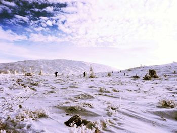 Group of people on rock against sky