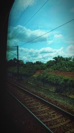 Railroad track against cloudy sky