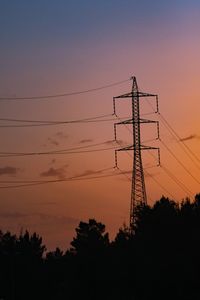 Low angle view of silhouette electricity pylon against sky during sunset