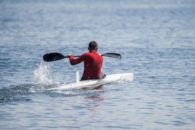 Rear view of boy in sea