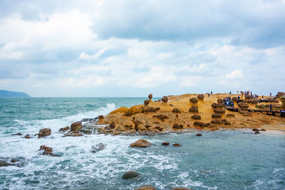 Rocks on beach against sky