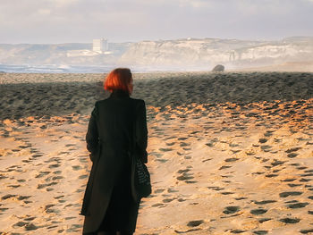 Rear view of woman standing on beach