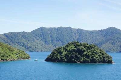 Scenic view of sea and mountains against clear sky