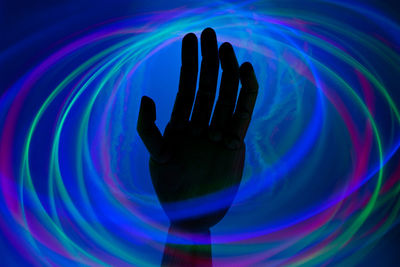 Digital composite image of hand holding illuminated light