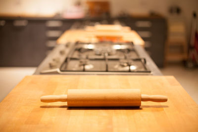 Close-up of rolling pin on table at kitchen
