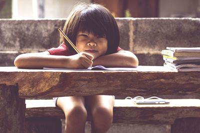 Portrait of girl sitting on table