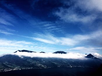 Scenic view of snowcapped mountains against blue sky