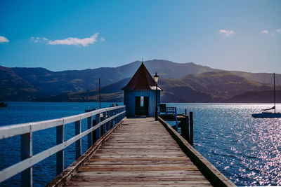 Pier over sea against blue sky