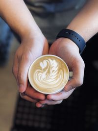 Cropped hand of woman holding coffee