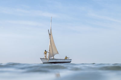 Sailboat sailing on sea against sky