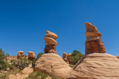 Low angle view of rock formations against blue sky