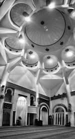 Low angle view of illuminated lights hanging from ceiling in building