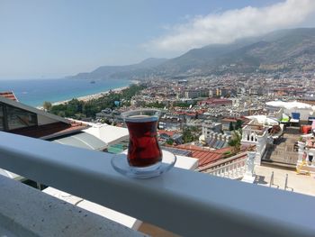 Close-up of drink on railing in city