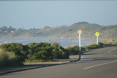 Road by sea against clear sky