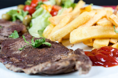Close-up of meat with french fries in plate