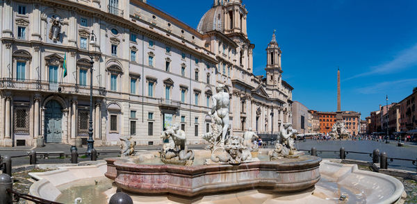 Statue of fountain in city against sky