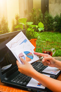 Cropped image of woman with graphs at table