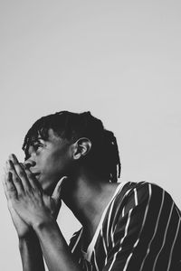 Portrait of young man looking away against white background
