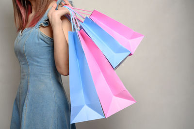 Midsection of woman standing against multi colored background