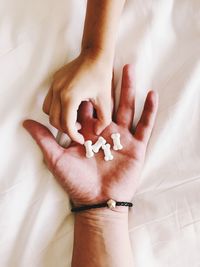 High angle view of woman hand on bed