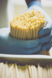 Cropped image of worker holding spaghetti in factory
