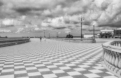 Cobblestone street by buildings against sky