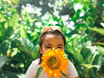 Close-up portrait of girl with yellow flower