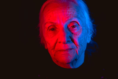 Close-up portrait of young man against black background