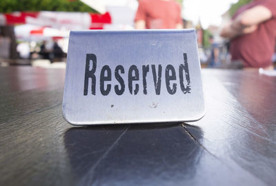 Close-up of information sign on table