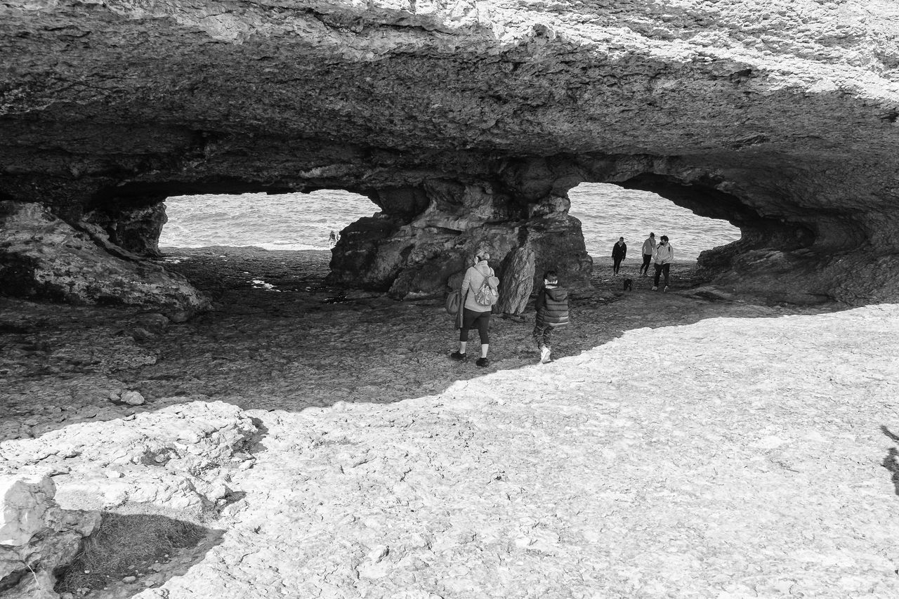 PEOPLE WALKING ON ROCK FORMATION