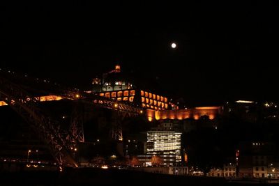 Illuminated buildings in city against sky at night