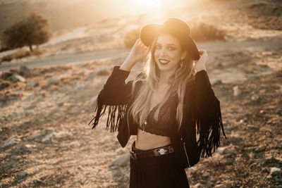 Portrait of smiling young woman standing on land