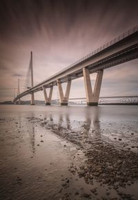 View of bridge over river at sunset