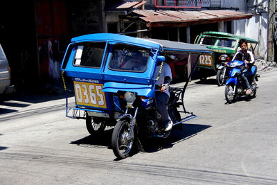 Man driving jinrikisha on city street