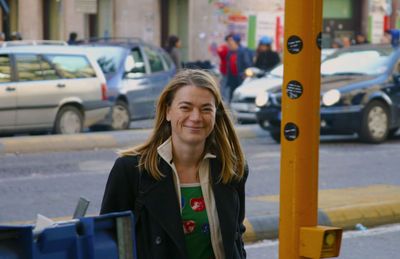 Portrait of smiling mature woman with cars in background