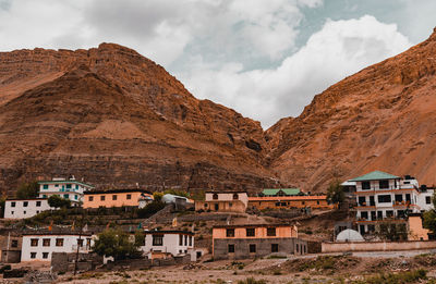 Houses in town against cloudy sky