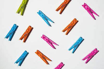 High angle view of colorful clothespins on white background
