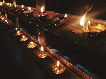 Close-up of illuminated candles burning at night