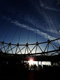 Low angle view of silhouette ferris wheel against sky