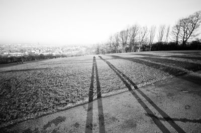 Road amidst field against clear sky