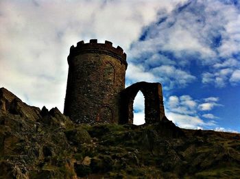 Low angle view of old ruin against cloudy sky