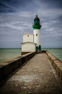 Lighthouse by sea against sky