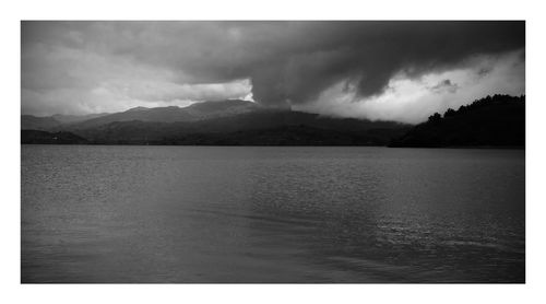 Scenic view of lake against cloudy sky